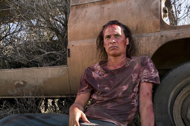 Nick sitting against an abandoned vehicle resting