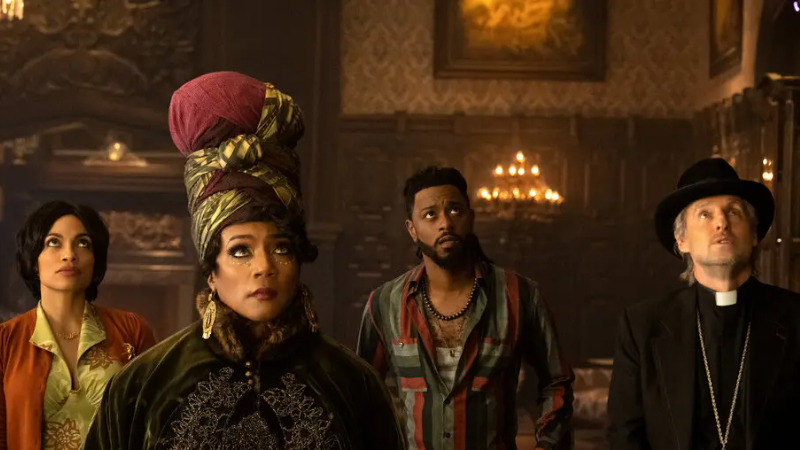 The main characters look up at something in in Haunted Mansion (2023), a remake of the first Disney theme park-inspired film.