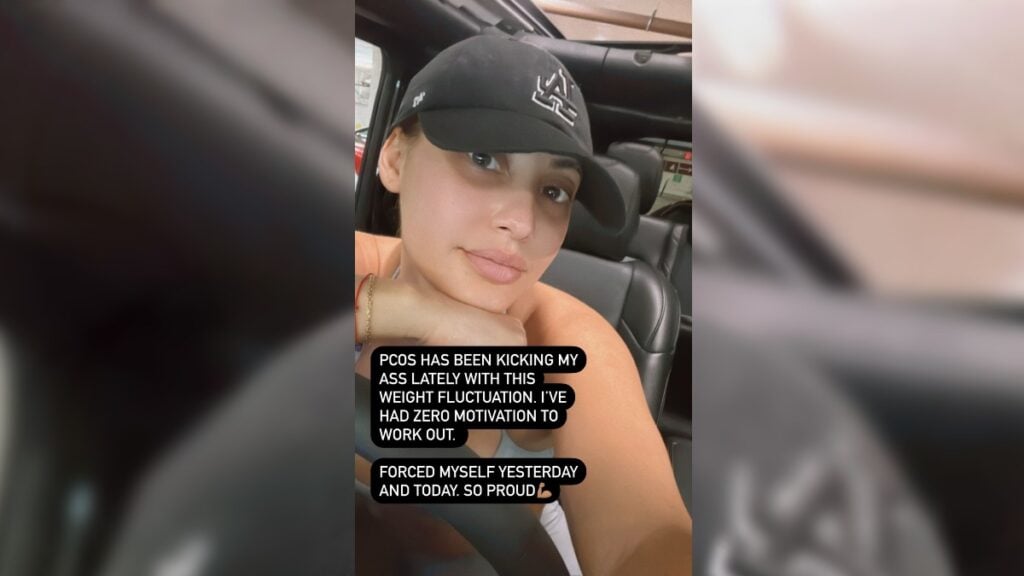 Francia Raisa in workout gear posing inside her car.