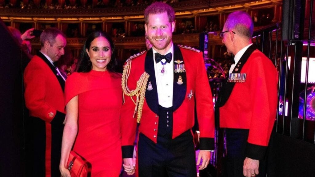 Meghan Markle in a red dress alongside husband Prince Harry.