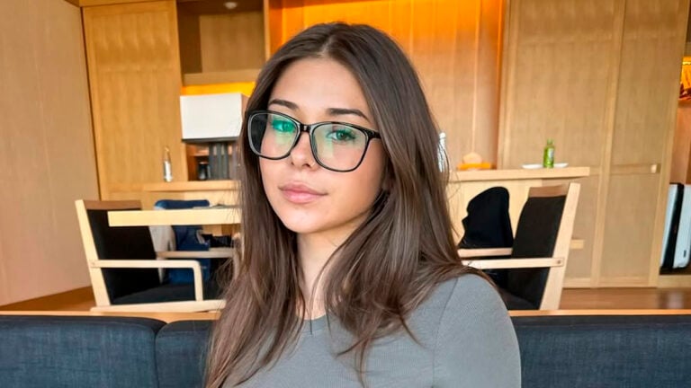 Sophie Rain poses wearing eye glasses in a living room
