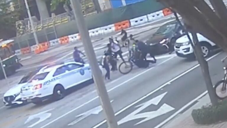 a victim is beaten by cyclists in miami florida, while cop does nothing