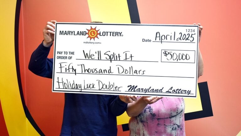 a mother and son holding a giant check with their lottery win written on the front